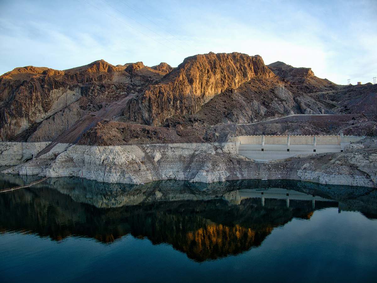 nature brown mountains beside body of water mountain